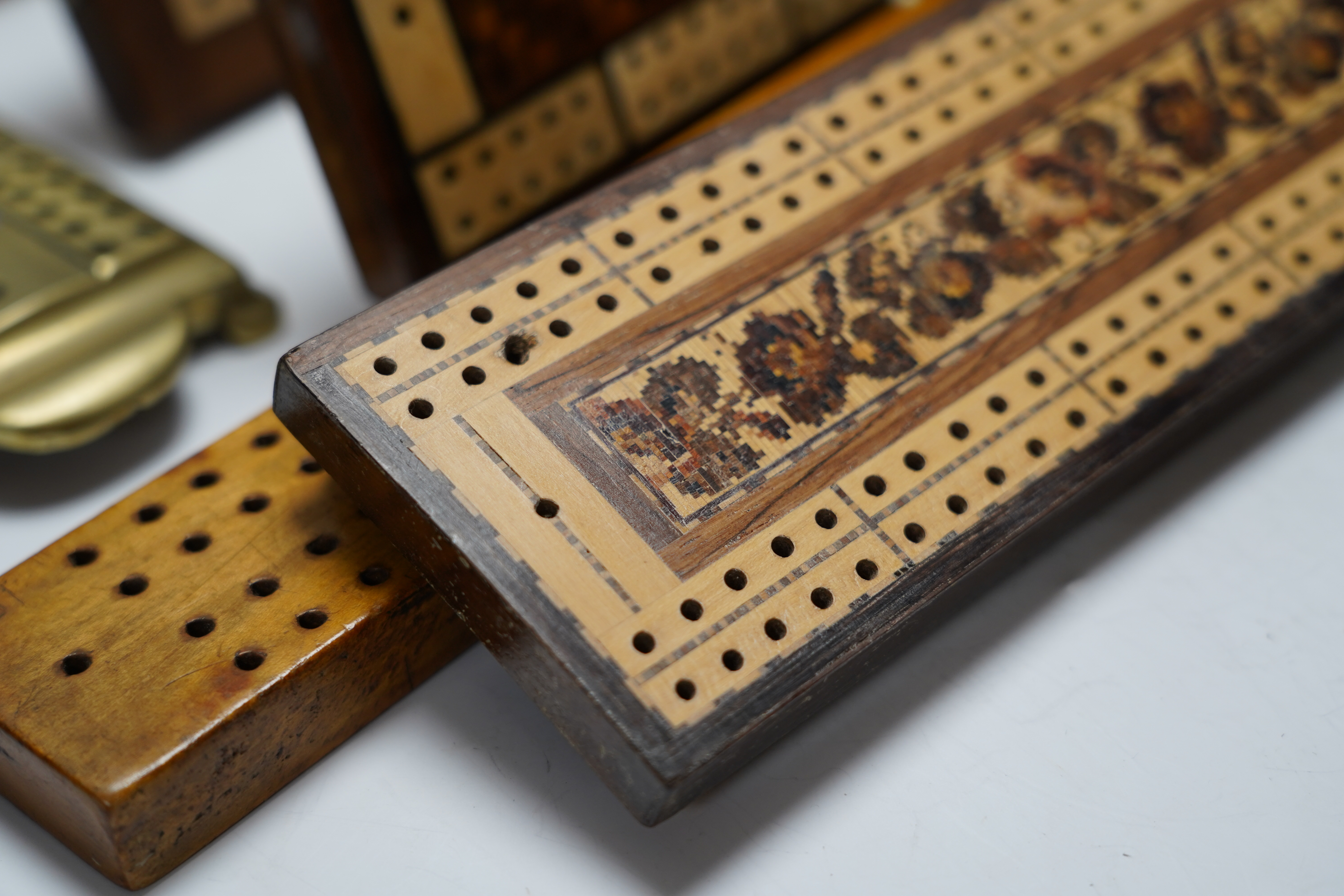 Nine cribbage boards including a horn example, 'Wills Tobacco' advertising and bone and marquetry examples, largest 42cm in length